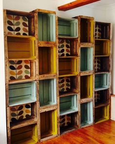 an empty room with many wooden boxes on the wall and wood flooring in front of it