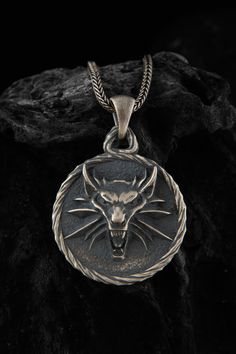 The silver wolf pendant is a stunning piece of jewelry that is perfect for fans Wolf lovers. Crafted from high-quality silver, this pendant features a beautifully detailed wolf head, a symbol that is closely associated with the Witcher universe. The intricate design and attention to detail make this pendant a truly unique and eye-catching accessory that is sure to draw compliments. Whether you wear it as a statement piece or as a subtle nod to your fandom, this pendant is a must-have for any Wit Wolf Medallion, Witcher Medallion, Wolf Pendant Necklace, Black Chain Necklace, Wolf Pendant, Wolves Pendants, Wolf Necklace, Wolf Jewelry, Silver Wolf