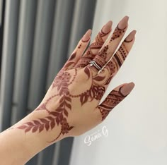 a woman's hand with henna tattoos on it