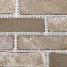 a brick wall that is made out of grey and brown bricks with white checkered fabric