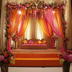 an orange and pink wedding stage decorated with flowers