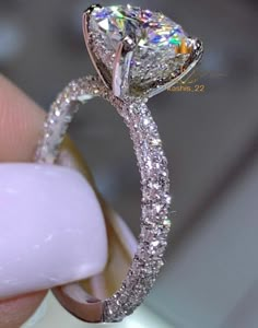 a close up view of a diamond ring on someone's finger