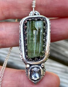 A beautiful and unique pendant that had been completely handcrafted solid fine silver. The center stone is a natural 10x20 mm green TOURMALINE crystal. This uncut tourmaline has great form and translucency + color. The accenting stone is a faceted oval 4x6 mm natural Herkimer Diamond quartz crystal.  I have hand carved this pendant in solid fine silver (.999). All work is hand done, no mold or stamping involved.. It has a free form look that has been pre oxidized to bring out the details of the Silver Emerald Rectangular Pendant Jewelry, Sterling Silver Necklace With Large Green Stone, Green Engraved Amulet Jewelry, Handmade Peridot Pendant Jewelry, Unique Peridot Jewelry For May Birthstone, Unique Untreated Sterling Silver Gemstones, Silver Peridot Jewelry With Gemstone, Green Tourmaline Pendant Jewelry, Handmade Green Rectangular Pendant Jewelry