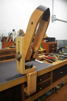 a machine that is sitting on top of a wooden table in a room with lots of tools