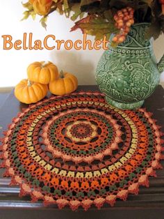 a crocheted doily sits on a table next to pumpkins