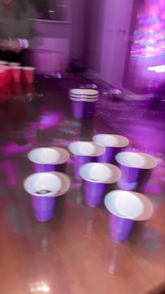 purple cups sitting on top of a wooden table