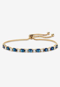 a gold bracelet with blue and white stones on the front, set in 18k yellow gold