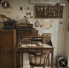 an old fashioned desk and chair in a room with pictures on the wall above it