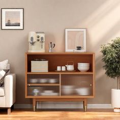 a living room with a couch, coffee table and potted plant on the shelf