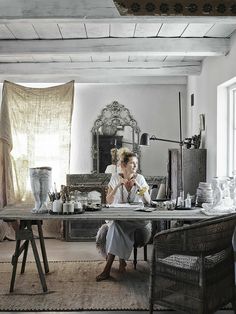 a woman sitting at a table in front of a window