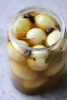 a jar filled with lots of yellow and white balls on top of a marble table