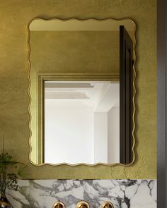 a bathroom sink with two faucets and a mirror above it on the wall