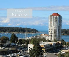 a city with lots of tall buildings next to the ocean and boats in the water