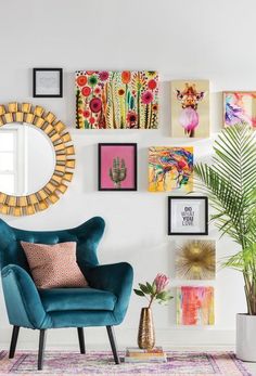 a living room filled with furniture and pictures on the wall behind a blue chair in front of a round mirror