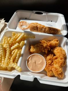 a plastic tray with chicken, fries and dipping sauce