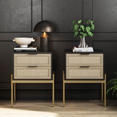 two nightstands with plants and books on them in front of a black painted wall