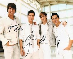 three men in white shirts and ties posing for a photo with one man holding his arm around the other