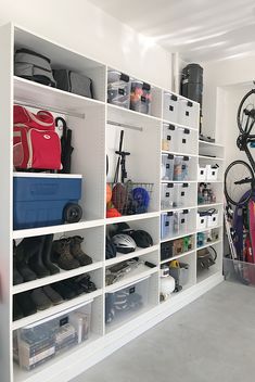 a room filled with lots of white shelving and storage bins next to each other