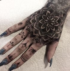 a woman's hand with black and white hendix tattoos on her fingers