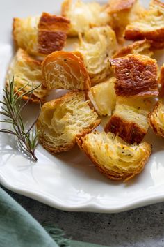 a white plate topped with sliced up oranges and rosemary sprigs on top of it