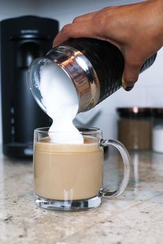 someone is pouring milk into a cup on the counter