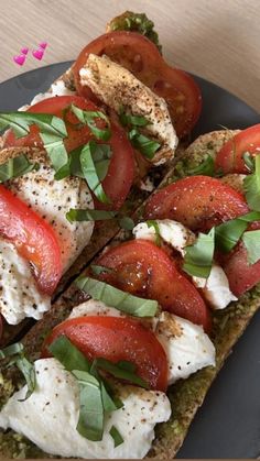 an open faced sandwich topped with tomatoes and mozzarella