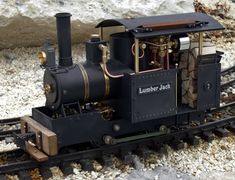 an old fashioned train is sitting on the tracks in the middle of snow covered ground