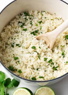 white rice and cilantro in a pot with a wooden spoon on the side