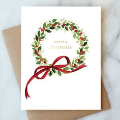 a christmas card with a red ribbon and holly wreath