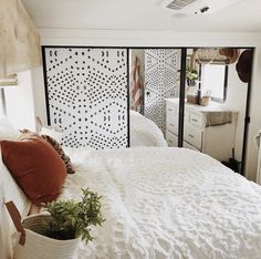 a white bed sitting in a bedroom next to a window