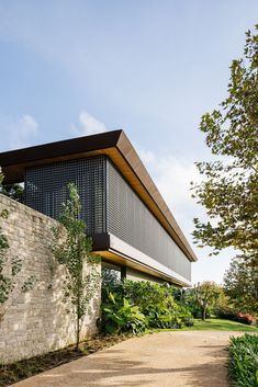 the house is surrounded by greenery and stone walls, along with a walkway leading up to it