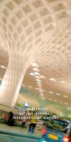 the interior of an airport with cars and people walking around in front of it,