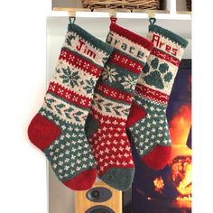 two christmas stockings hanging from a rack next to a fireplace