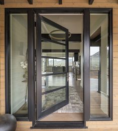 an open door leading into a large room with wooden walls and floor to ceiling windows