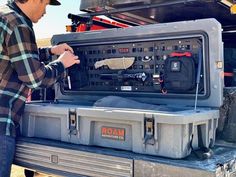 a man standing next to an open tool box