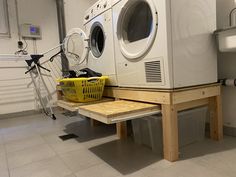 a washer and dryer sitting on top of a wooden shelf in a room