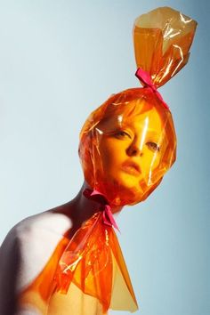 a woman with an orange plastic bag on her head