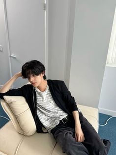 a young man sitting on top of a white couch