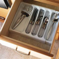 an open drawer with silverware in it