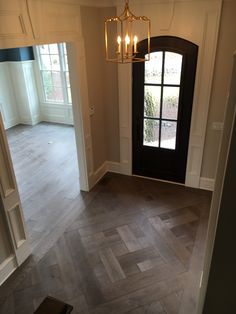 an empty entryway with a chandelier hanging from it's side door