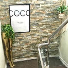 there is a plant next to the stairs in this office building with a sign that says coco on it