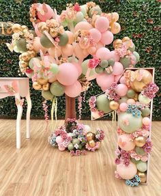 the balloon tree is decorated with pink, green and gold balloons that are hanging from it's branches