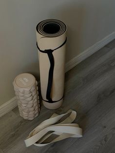 a roll of yoga mat sitting on the floor next to a stack of rubber bands