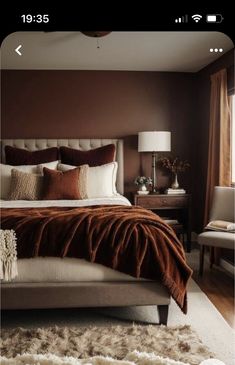 a bedroom with brown walls and white bedding