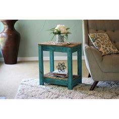 a living room with a chair, table and flowers on the end table in front of it