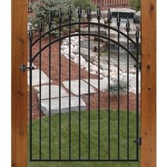 an iron gate in front of a wooden fence