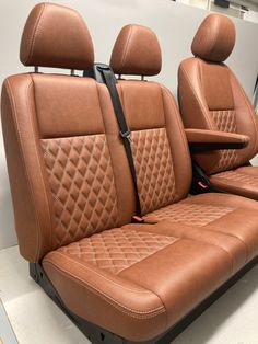 two tan leather seats with diamond stitching on the front and back, in a showroom