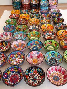 many colorful bowls are lined up on the table