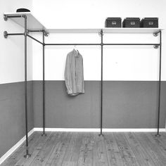 a coat rack with two coats hanging from it's sides and three bins on the wall