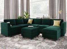 a living room with a large green sectional couch and matching footstool in front of a window